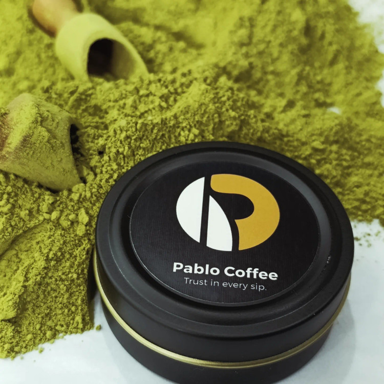 قوطی فلزی مشکی با لیبل پابلو کافی حاوی پودر سبز روشن ماچا خالص با بافت نرم و آسیاب شده به روش سنتی سنگی، نشاندهنده کیفیت Ceremonial.